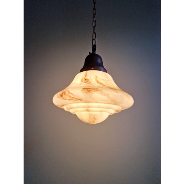 Art deco pendant light in marbled opaline glass in shades of light yellow and burgundy, with a copper mount. manufacturer:...