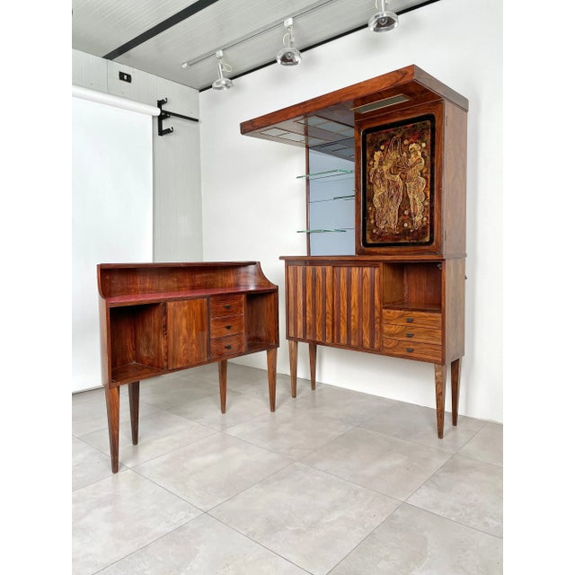 Mid-Century Modern Italian bar cabinet in rosewood and glass with the peculiarity of being composed of two separate units....