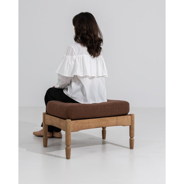 A charming French oak stool from the 1970s, featuring a solid wood base with softly rounded corners and turned legs. The...