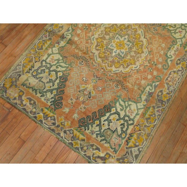 A early 20th century antique Turkish Oushak rug in predominant orange accents.