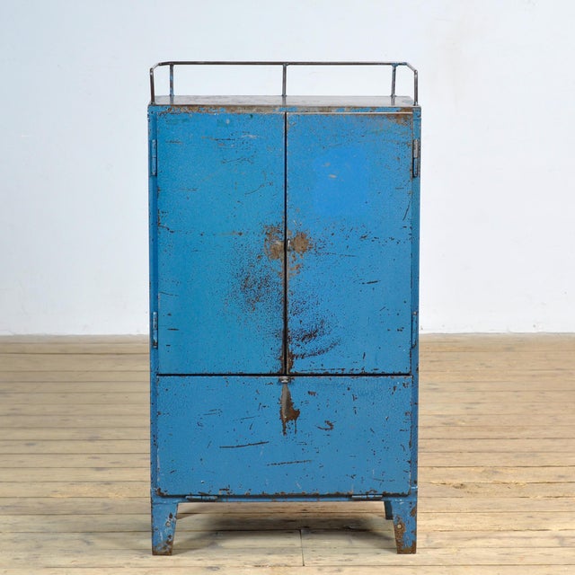 Bring a touch of vintage industry to your interior with this robust 1970s cabinet. Made of iron and finished in a blue hue...