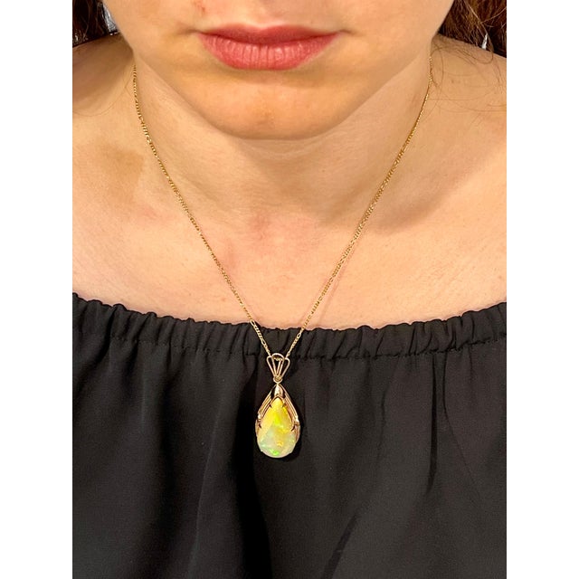 Approximately 18 Carat Pear Ethiopian Opal Pendant / Necklace 14 Karat Yellow Gold Estate This spectacular Pendant...