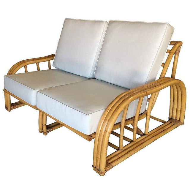 Rare museum-quality Paul Laszlo designed three-strand rattan settee. This loveseat dates from 1941 and features a unique...