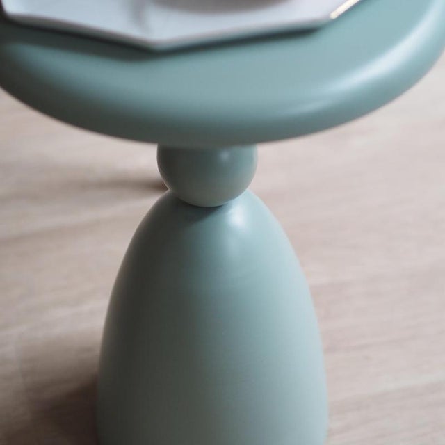 The side table is a newly produced piece of furniture made of lacquered metal with a rotationally symmetrical structure...
