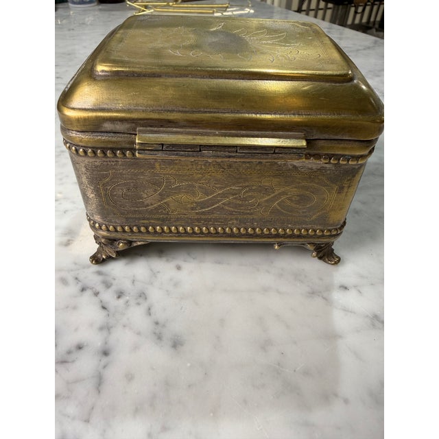 A beautifully crafted vintage solid brass jewelry casket featuring elegant hand-engraved floral decoration and finely...