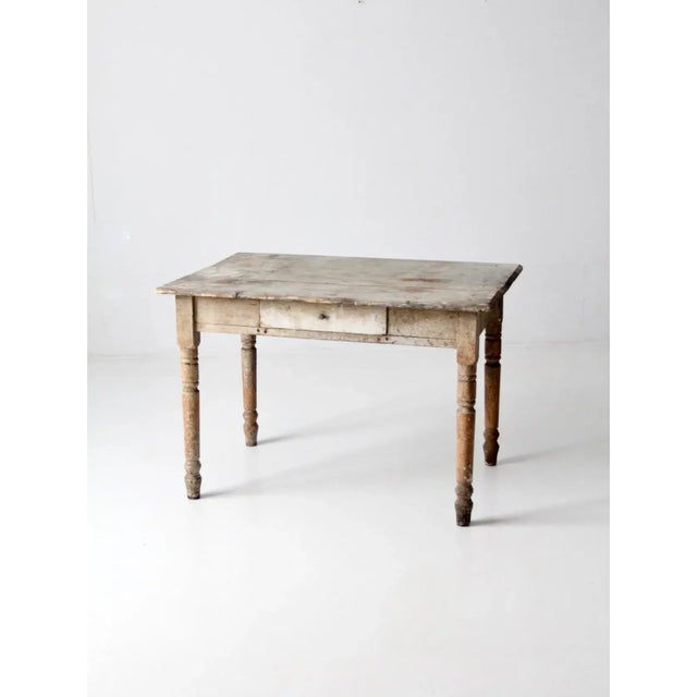 A character-rich kitchen table featuring turned legs and a softly worn gray painted top. The single drawer adds function...
