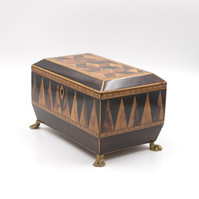 Specimen-wood tea caddy with canted lid, the top set with a large panel of perspective cube (tumbling-block) parquetry...