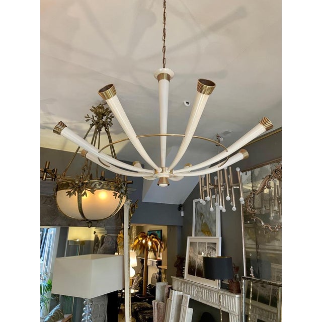 A large Italian Mid-century chandelier in Brass with Ivory white painted arms and stem. the tapered centre stem supporting...