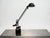 Vintage black counterbalance desk lamp featuring a long adjustable arm, cylindrical counterweights, and a rounded metal...