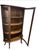 An antique curved-glass curio cabinet retaining its original glass and finish, offering an elegant way to display...