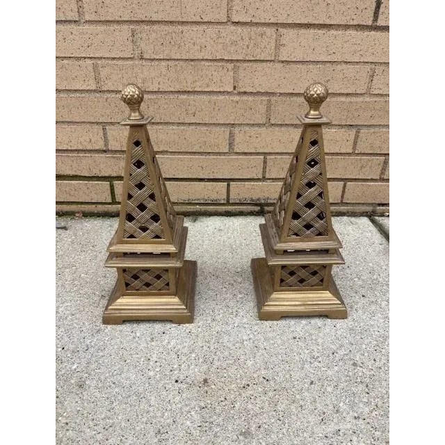 Each obelisk is crowned with a detailed finial in the shape of a classic pinecone, symbolizing hospitality and timeless...