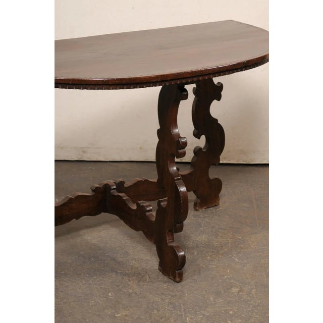 A carved-wood Italian demi-lune console from the 19th century. This antique table from Italy features a half-moon shaped...