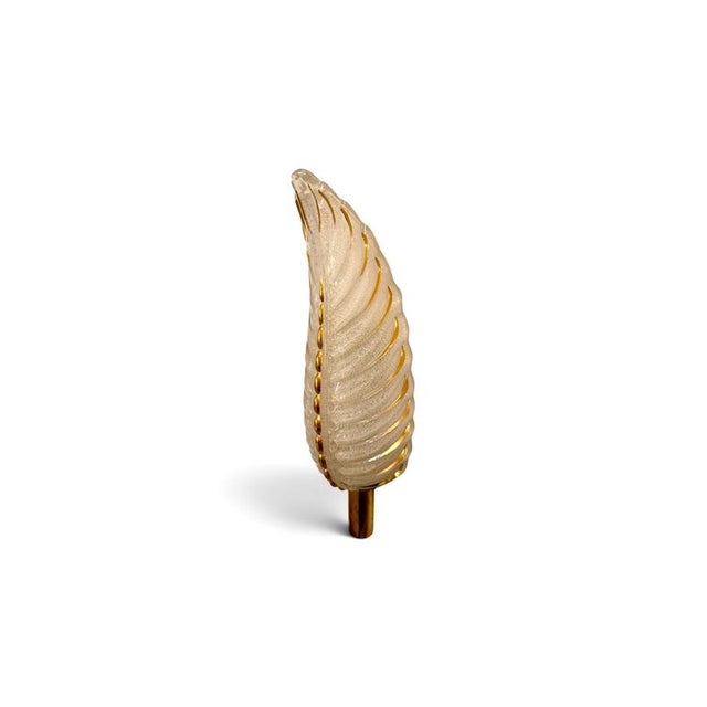 An elegant pair of french art deco wall sconces, the feather-shaped shades in thick frosted pressed glass with hand-...