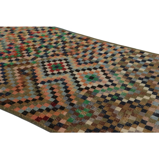 Made with hand-knotted wool circa 1950-1960, this 5x10 vintage Turkish rug of all over diamond medallion design is an...