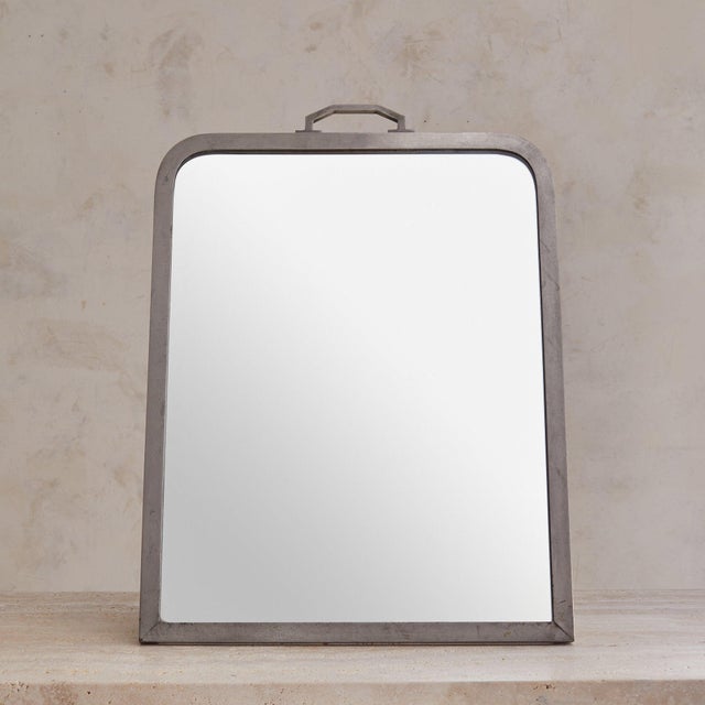 A 1940s French Art Deco vanity mirror, sourced in the South of France. The mirror rests within a silver-plated geometric...