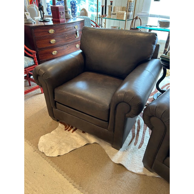 Big comfy leather club chairs having rolled arms and removeable seat and back cushions, held in place with Velcro. Barely...