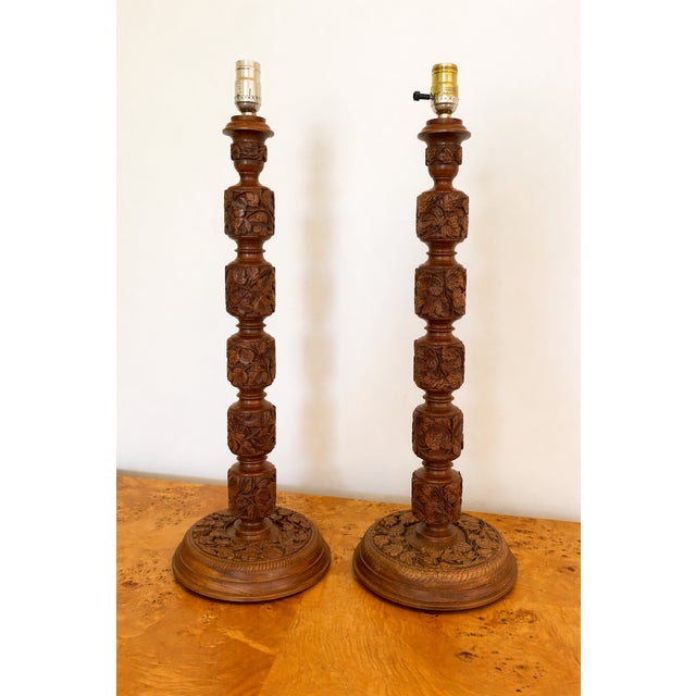 Matched pair of hand-carved wood table lamps from Kashmir, India. Each lamp features deeply carved chinar leaf and vine...