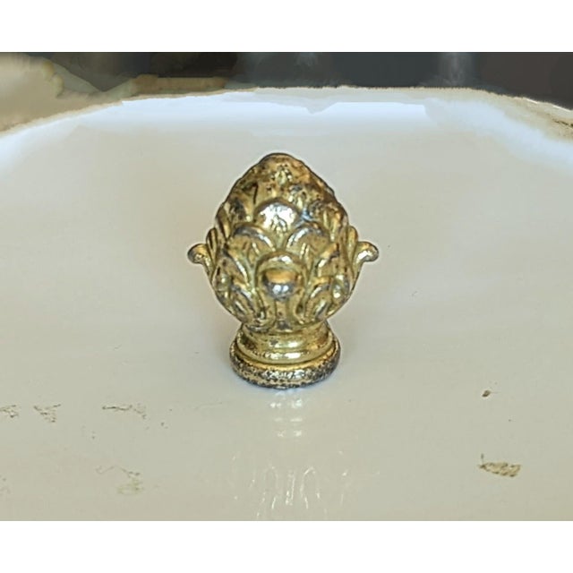 Weighty metal acorn Fineal. It is heavy and none magnetic. However, it appears to have a silver tone coming through. The...