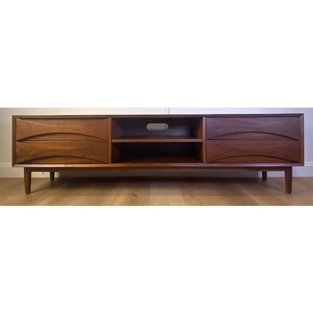 This mid‑century style solid walnut credenza features a striking sculpted front design and a long, low profile ideal for...