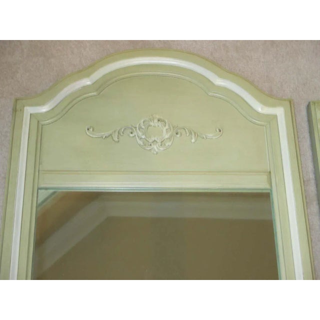 Beautiful pair of celery green painted wooden mirrors with decorative accent. Hanging hardware is attached.