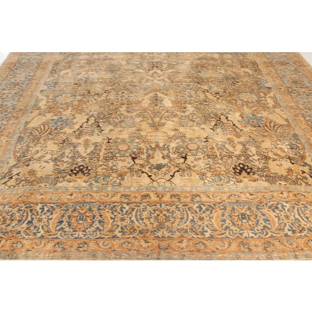 This circa-1920 antique Kirman Persian carpet features an elaborate all-over design of floral abstractions and arabesques...