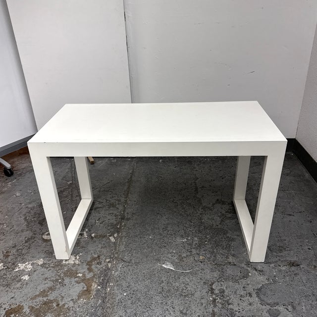 Design Plus Gallery presents a Contemporary White Parsons-Style Writing Desk. The rectangular desk has a streamlined...