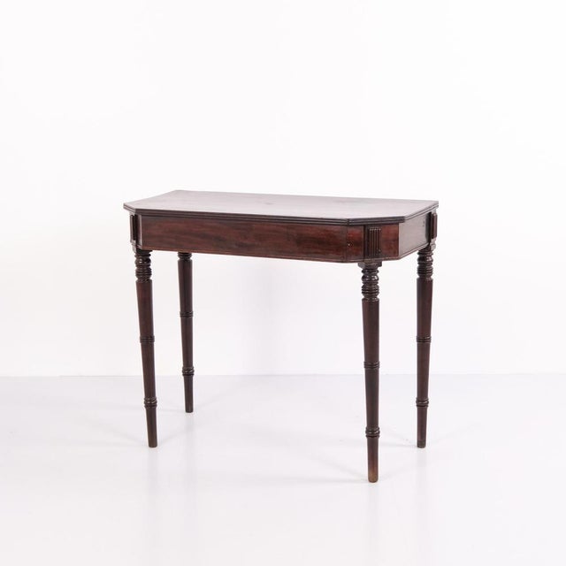 Mahogany games table with turned tapered legs dating from the 1880s. The table features a classic design with a folding...