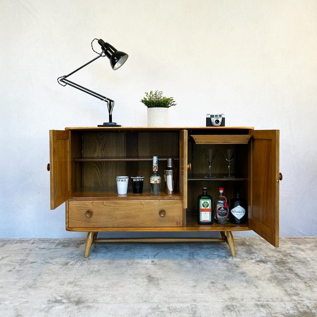 Solid elm construction on turned legs with stretcher rail base. Exposed finger-jointed corners throughout. Three framed-...