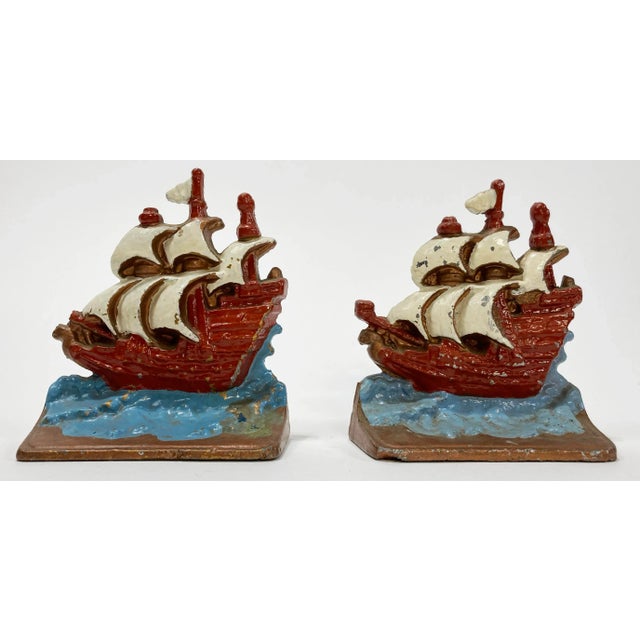 Wonderful vintage pair of cast aluminum bookends featuring ship motif. Each is enamel painted in red, white and blue,...