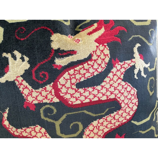 The Schumacher Bixi Velvet Pillows showcase striking dark sapphire background adorned with vibrant fuchsia and beige...