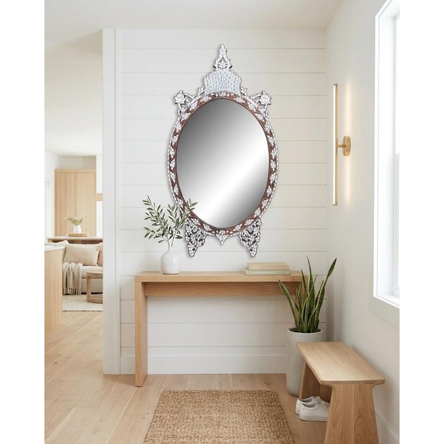 A truly exquisite mother-of-pearl inlaid mirror, masterfully crafted to showcase timeless artistry. Its exotic oval...