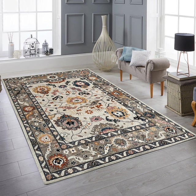 A hand-knotted wool rug, made in India and measuring 8' x 10'. Floral drawing carried across the field inside a...