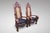 A pair of impressive carved walnut elephant high backed Throne Armchairs, cane back and seat rest, with a fitted black...