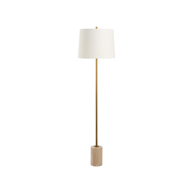 This contemporary floor lamp features a travertine base accented by a sleek metal body in a rich gold finish. Its...