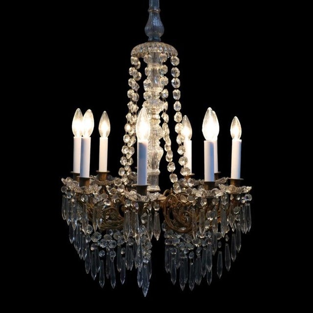 This vintage French Empire style chandelier, dating to approximately 1940, features a decorative basket form adorned with...