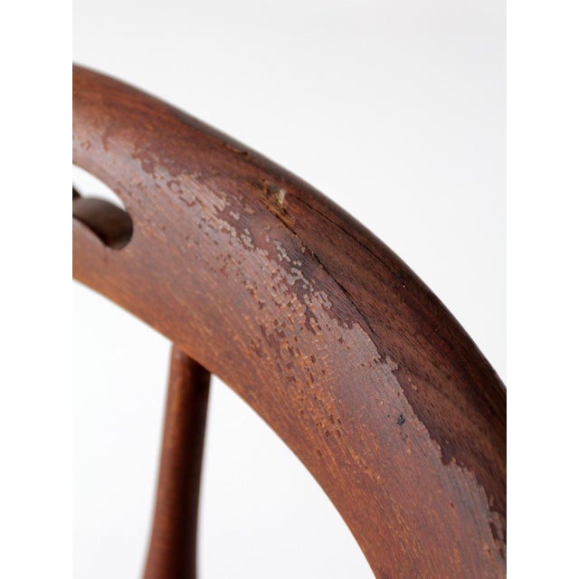 An antique Windsor bow back chair with a beautifully arched crest rail, turned spindle back, and hand-caned seat. The...