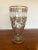 A beautiful medium sized vintage glass vase having ornate gold leaf patterned embellishments.