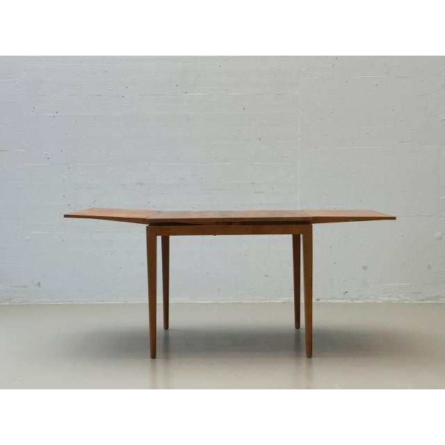 This elegant extendable wooden dining table impresses with its timeless mid-century design, clean lines, and exceptionally...