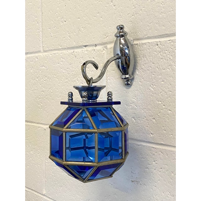 Pair of wall lamps in silvered brass and cut blue glass. European Plug (up to 250V).The wiring of this item may be...