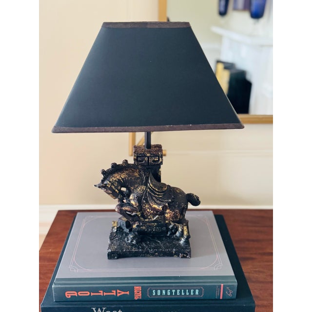 Vintage black and gold horse lamp with original black shade. It’s a great size and feels quite dramatic. It is in...