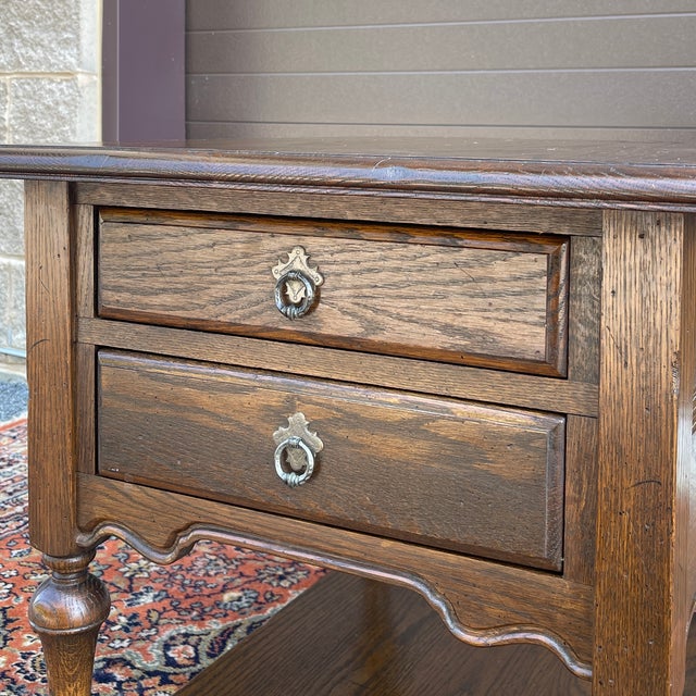 A late 20th century Ethan Allen Royal Charter collection Jacobean oak side table having two dovetailed drawers with brass...