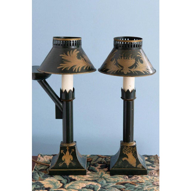 This elegant pair of early 20th-century French tole oil lamps is painted in a rich dark green, adorned with painterly gold...