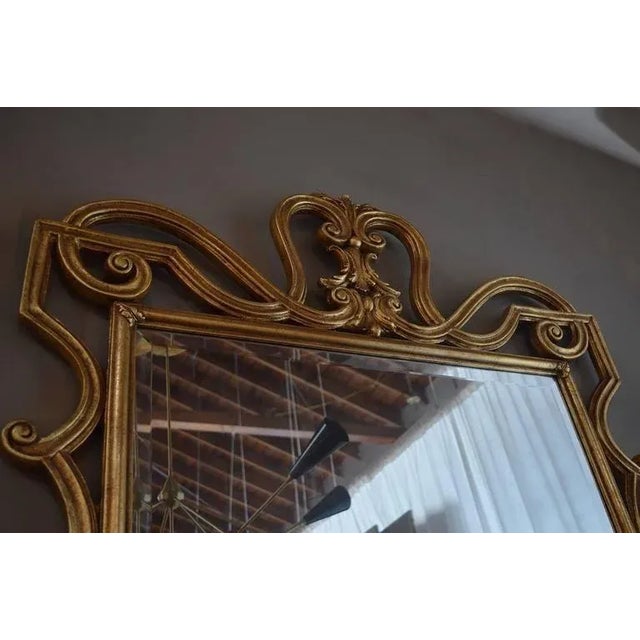 The frame of the mirror is hand-carved wood with beautiful details and gold leafed.