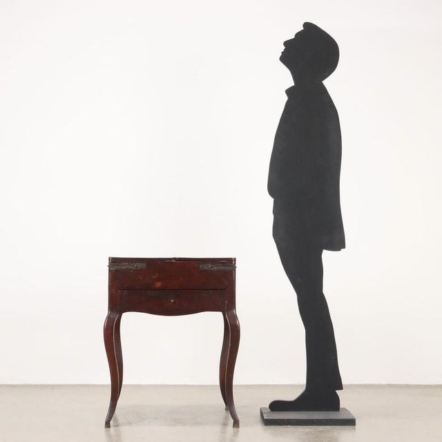 Walnut work table, top that opens with a flap and a pair of shelf-holding pulls, central open compartment inside with...