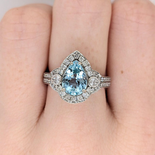 A rare santa maria aquamarine rests in a deep sea-blue at the centre of this solid 14K white gold ring, surrounded by...