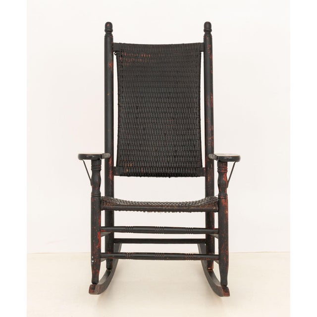 American Rustic Black and Red Painted Wood and Woven Rush Seat and Back Rocking Chair. 46" H x 27.25" W x 33.25" D; seat:...