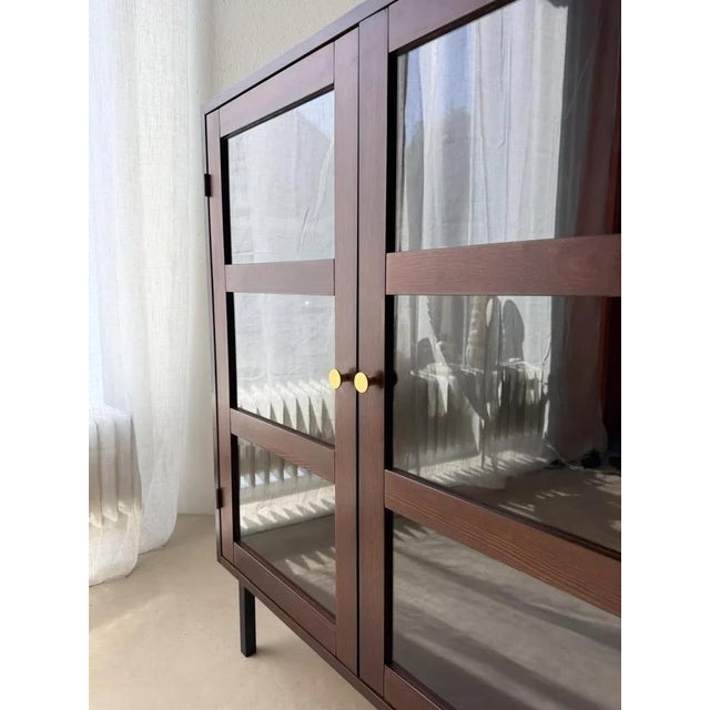 This display cabinet is designed with an eye for proportion. The generous glass panels are framed by slender wooden...