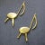 A Pair of mid century modern solid brass musical note fireplace andirons with back fasteners to secure log holder supports...