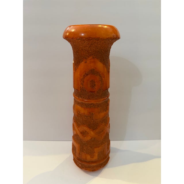 Striking mid-century stoneware vessel featuring a vivid orange glaze with heavily textured geometric relief decoration....