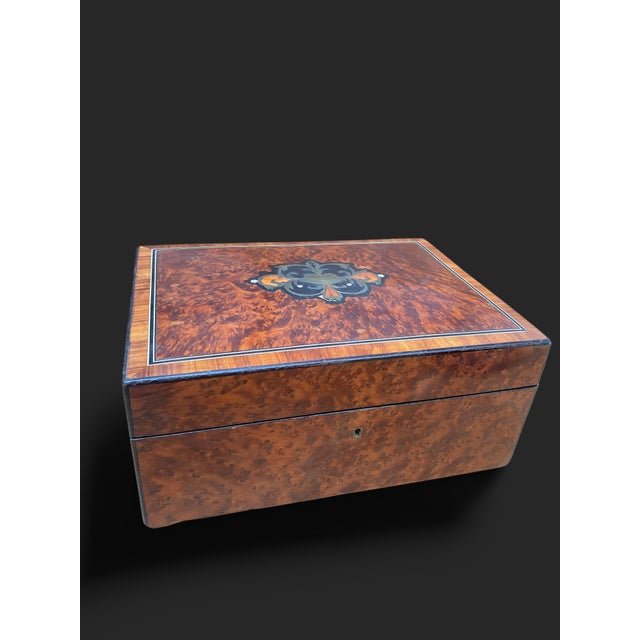 Rectangular box veneered in burl wood, with marquetry decoration on the lid (brass, ebony, and stained wood). European...